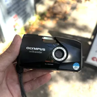 An Olympus Stylus Epic 35 mm film camera, held in hand