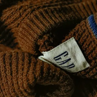 A brown Gap knit sweater, its label showing